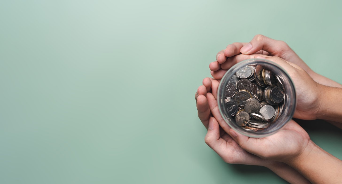 hands of adult and child holding money jar, donation, saving, fu